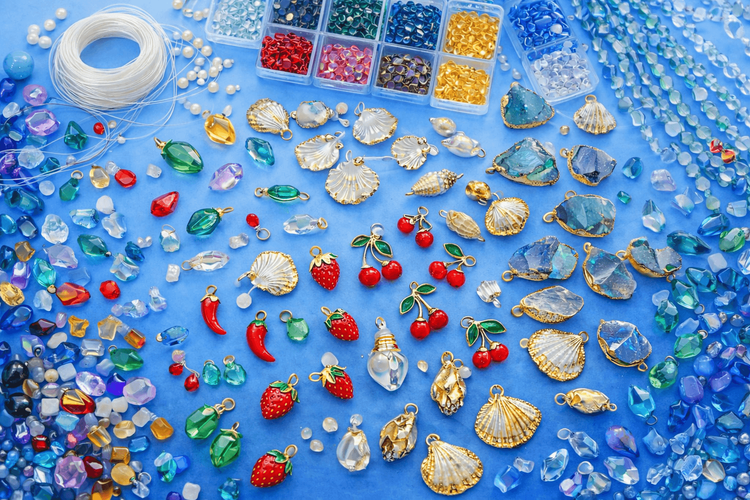 Collection of beads, pendants, and charms spread on a blue surface